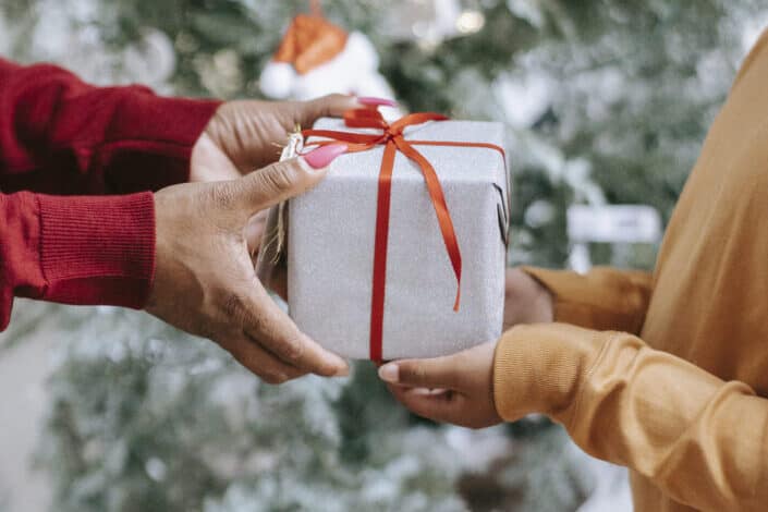 man handing a gift over to a woman