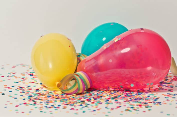 three balloons with confetti around them