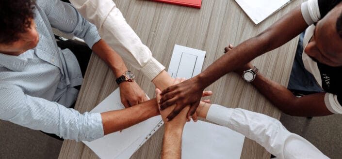 five hands stacked in the center