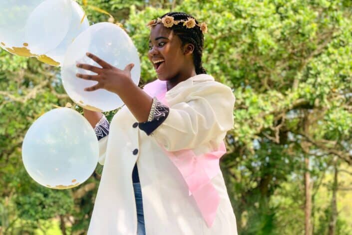 woman holding white balloons looking fascinated