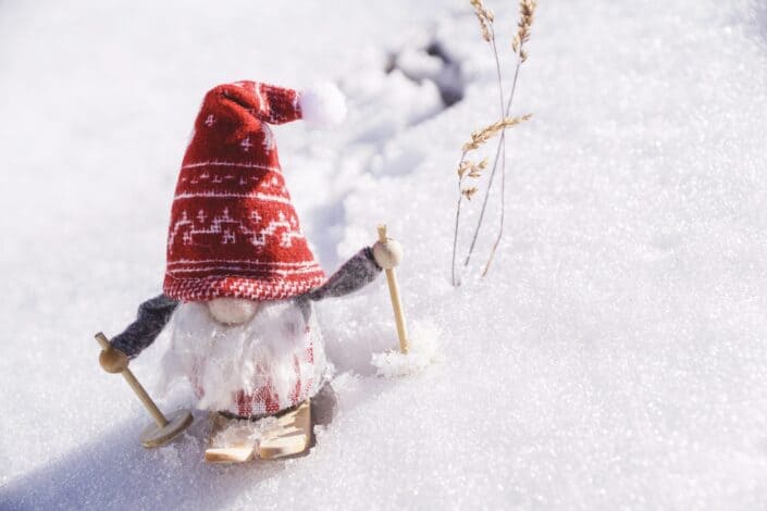 felt elf figure sledding in artificial snow