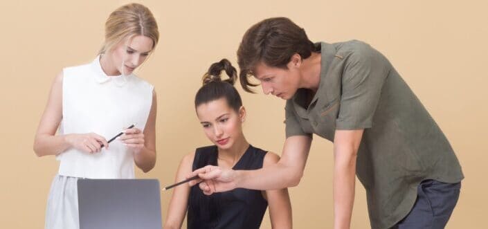 three adults discussing over a laptop