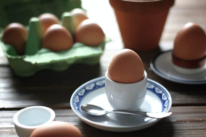 hardboiled egg on an egg plate with a spoon on the side