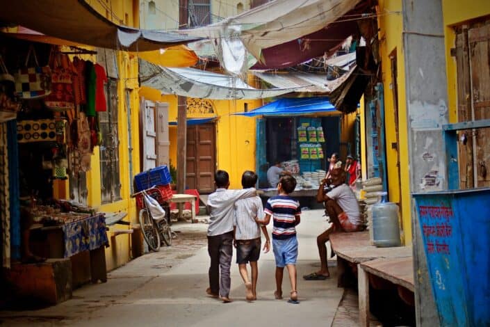 three little boys walking down a colorful alley