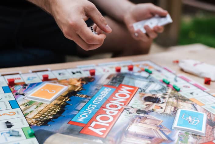 Faceless man preparing to roll dices while playing board game