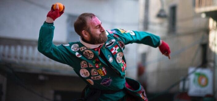 man about to throw an orange ball with full force