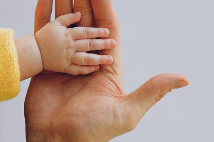father holding hand of toddler