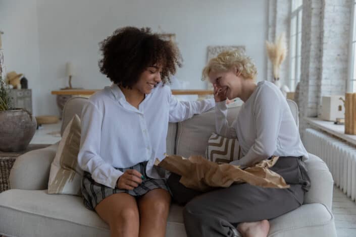 Two women laughing on couch