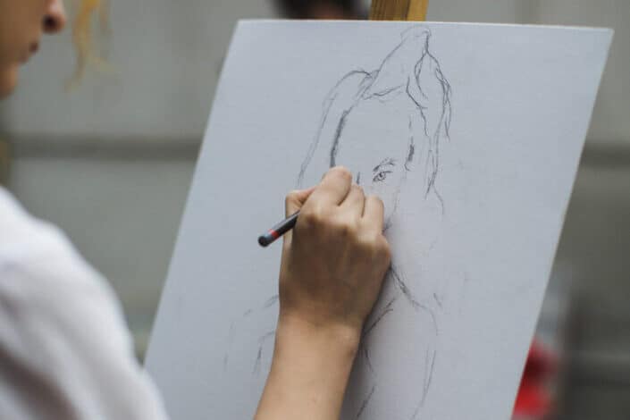 a guy sketching on a card board