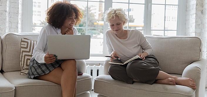 Two ladies sitting on the couch, discussing