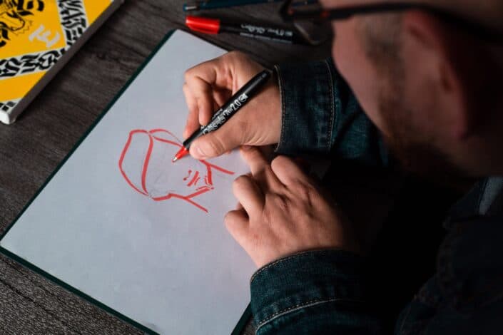 a man sketching on a white paper