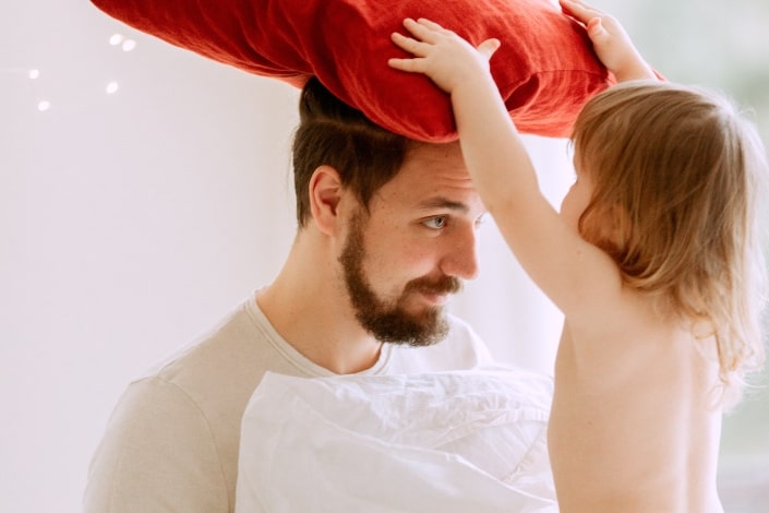 father and daughter bonding with red pillow
