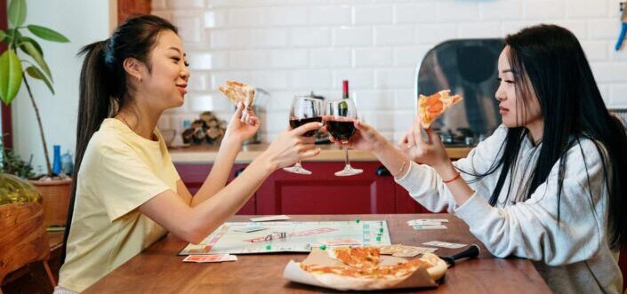 Two girls having good time playing board 