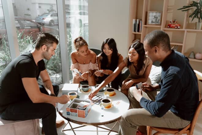 group of people playing board games - dinner party games for adults