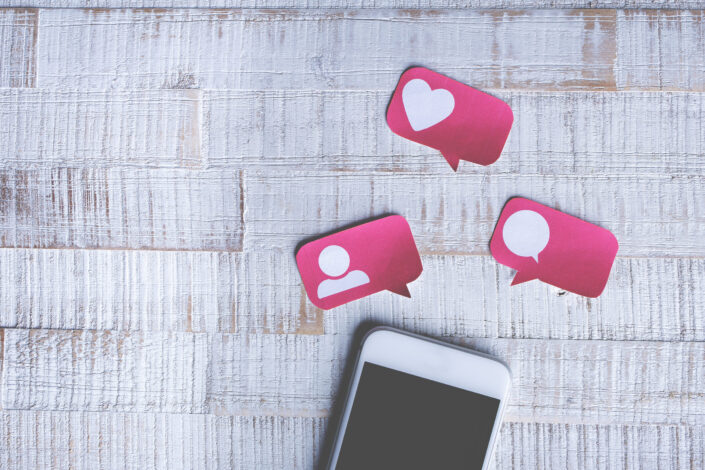 White smartphone with like, comment, friend cut outs