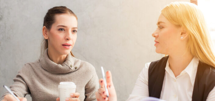 Two women talking about something.