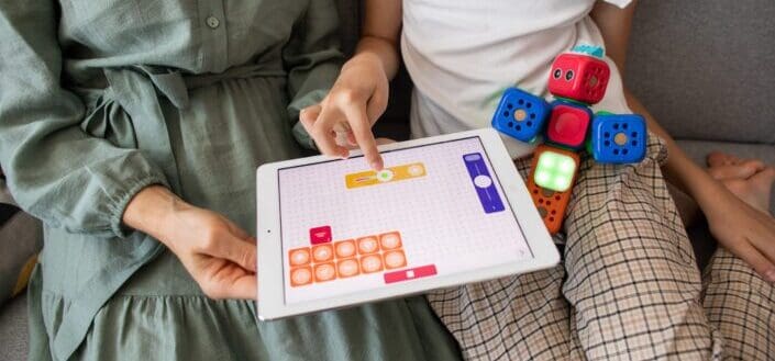Kid and her mother playing on her ipad