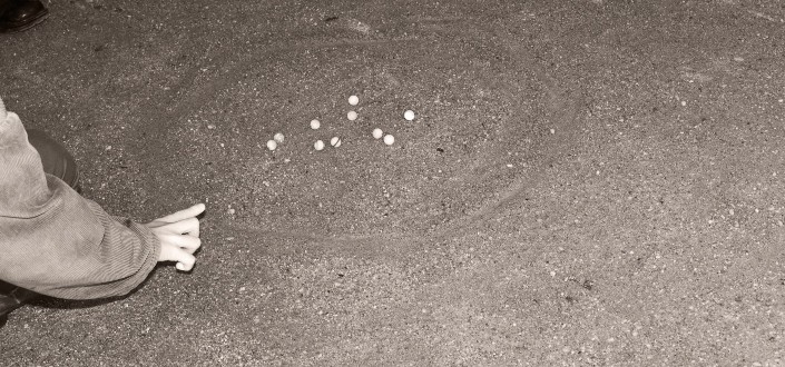 Kid playing marbles on the ground