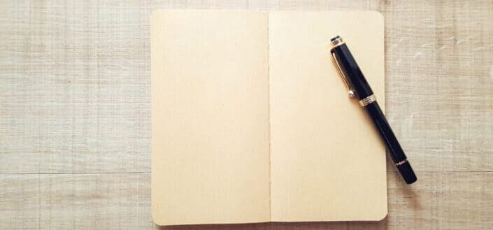 Pen on Top of Open White Notebook