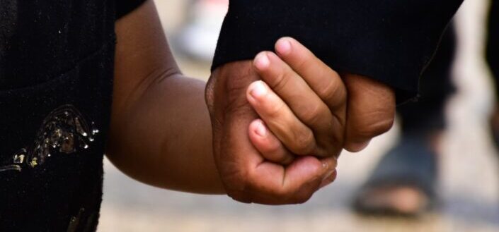 person in black t-shirt holding persons hand