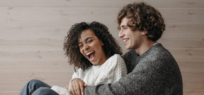 Woman Laughing While a Man is Hugging Her