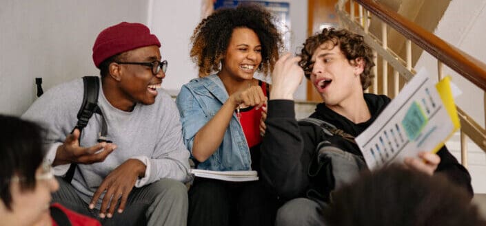 Schoolmates Laughing While Sitting on the Stairs