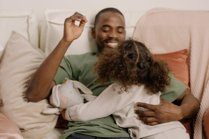 Man in Green Shirt Playing With His Daughter
