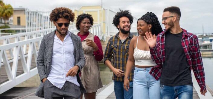 Group of Smiling People Walking on Boardwalk