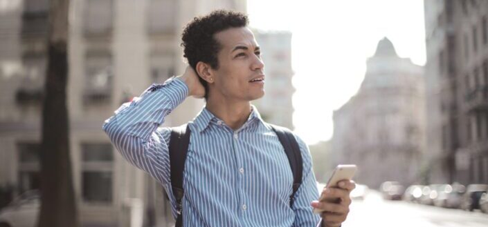 Confused Man Using Smartphone on Street