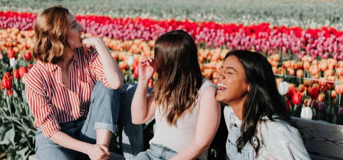 Women Sitting on a Wooden Bench by the Tulip Flower Field