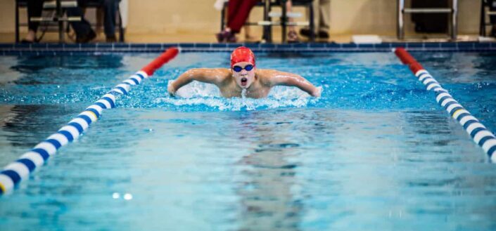 man wearing googles and orange swimming cap