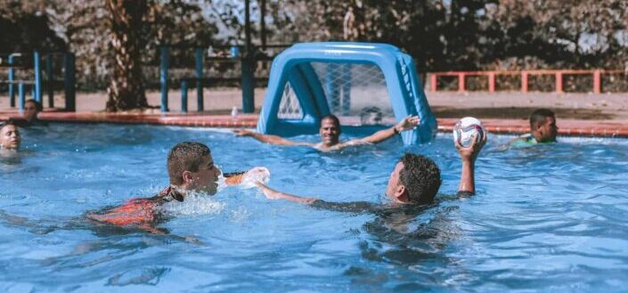 People on swimming pool playing ball