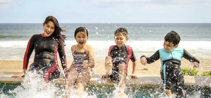 Woman and three children playing water