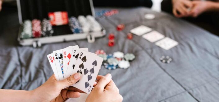 People Playing Poker on The Bed