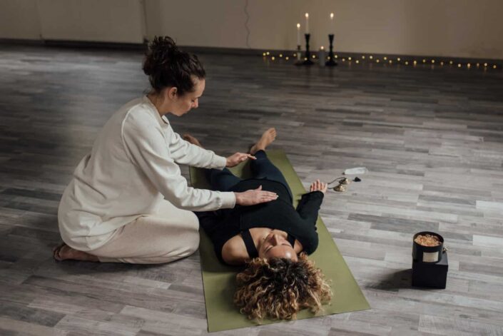 Therapist Massaging a Woman Lying on Mat